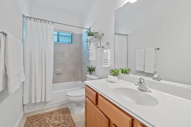 a bathroom with a granite countertop sink a toilet and shower