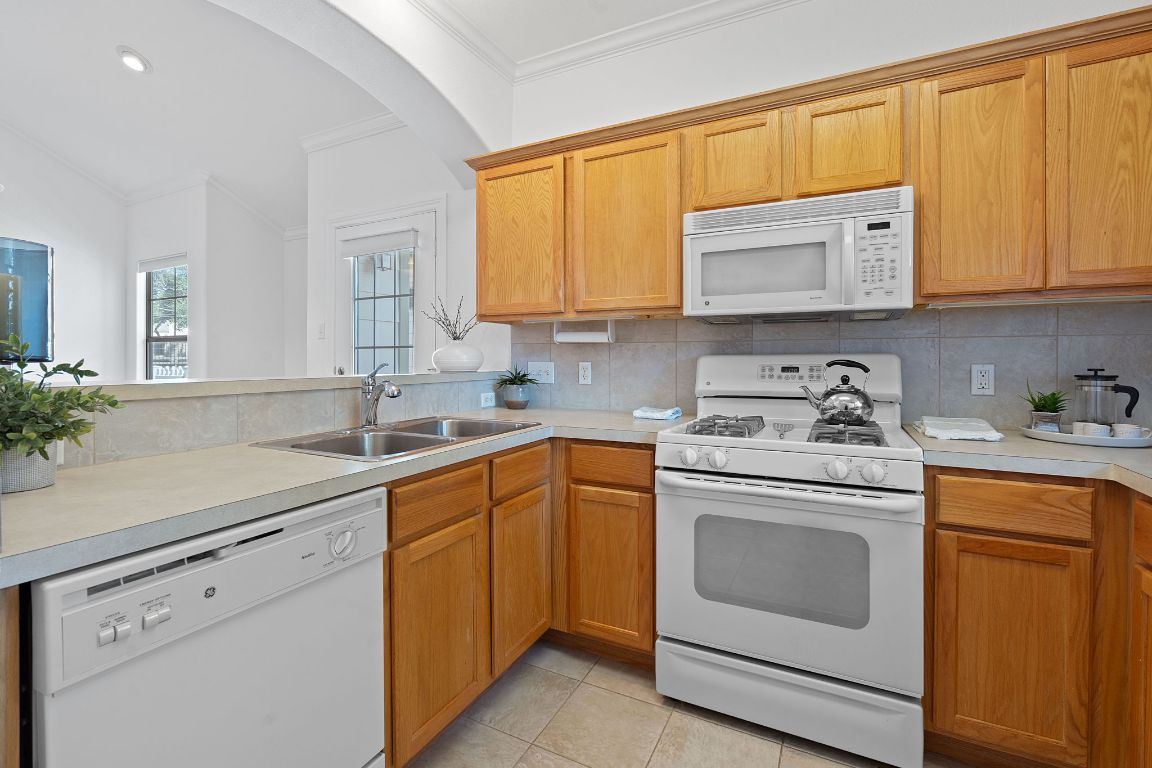 6801 Beckett Road, Unit 119R Austin, TX 78749 - Photo 10 of 26 a kitchen with white cabinets sink and stove