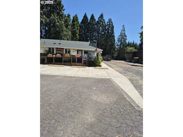 a view of a patio with table and chairs under an umbrella with a small yard