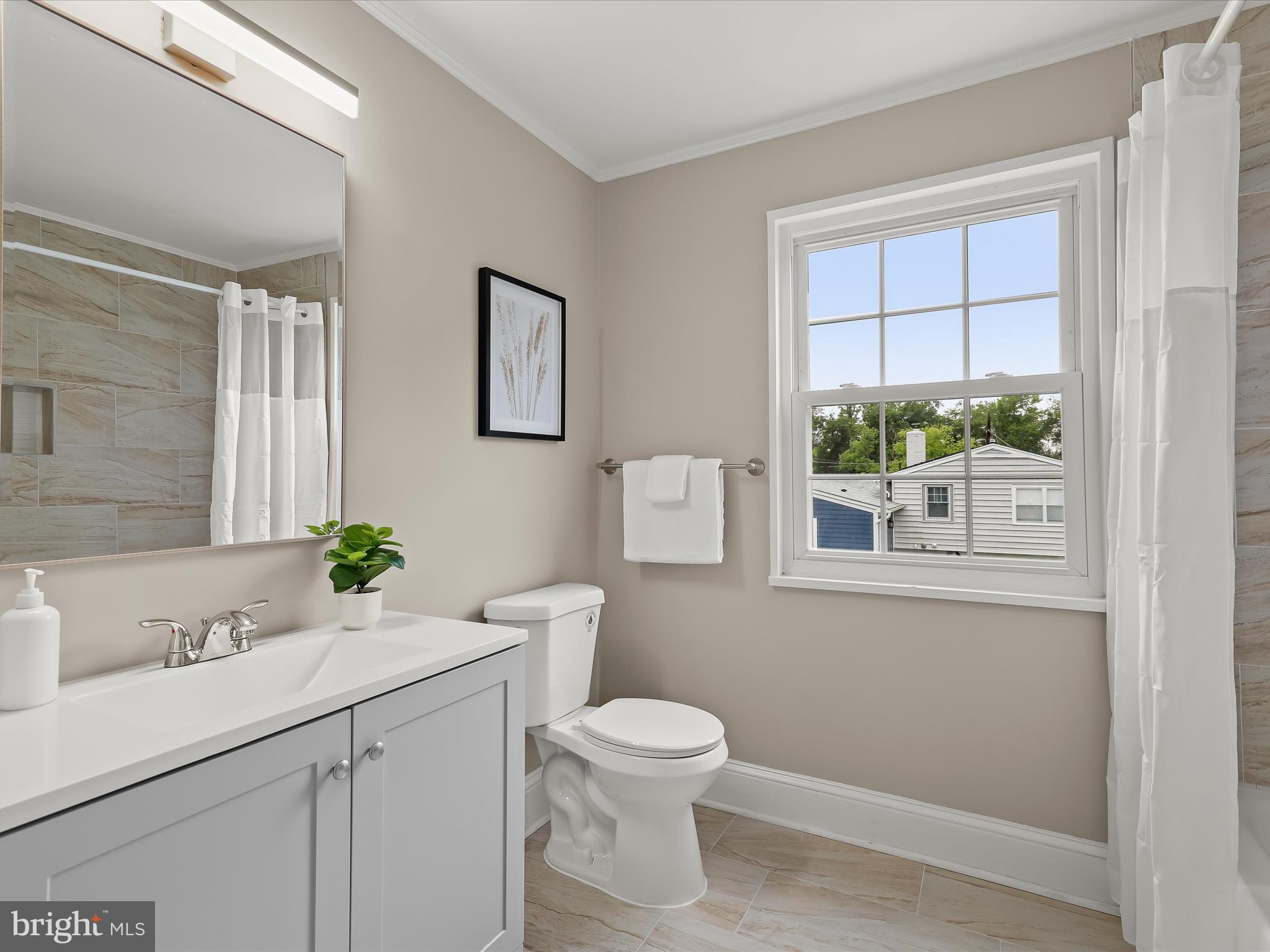 13214 Holdridge Road Silver Spring, MD 20906 - Photo 20 of 33 a bathroom with a toilet a sink and a window