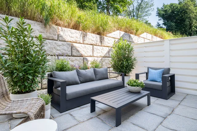 a view of a patio with couches table and chairs and potted plants