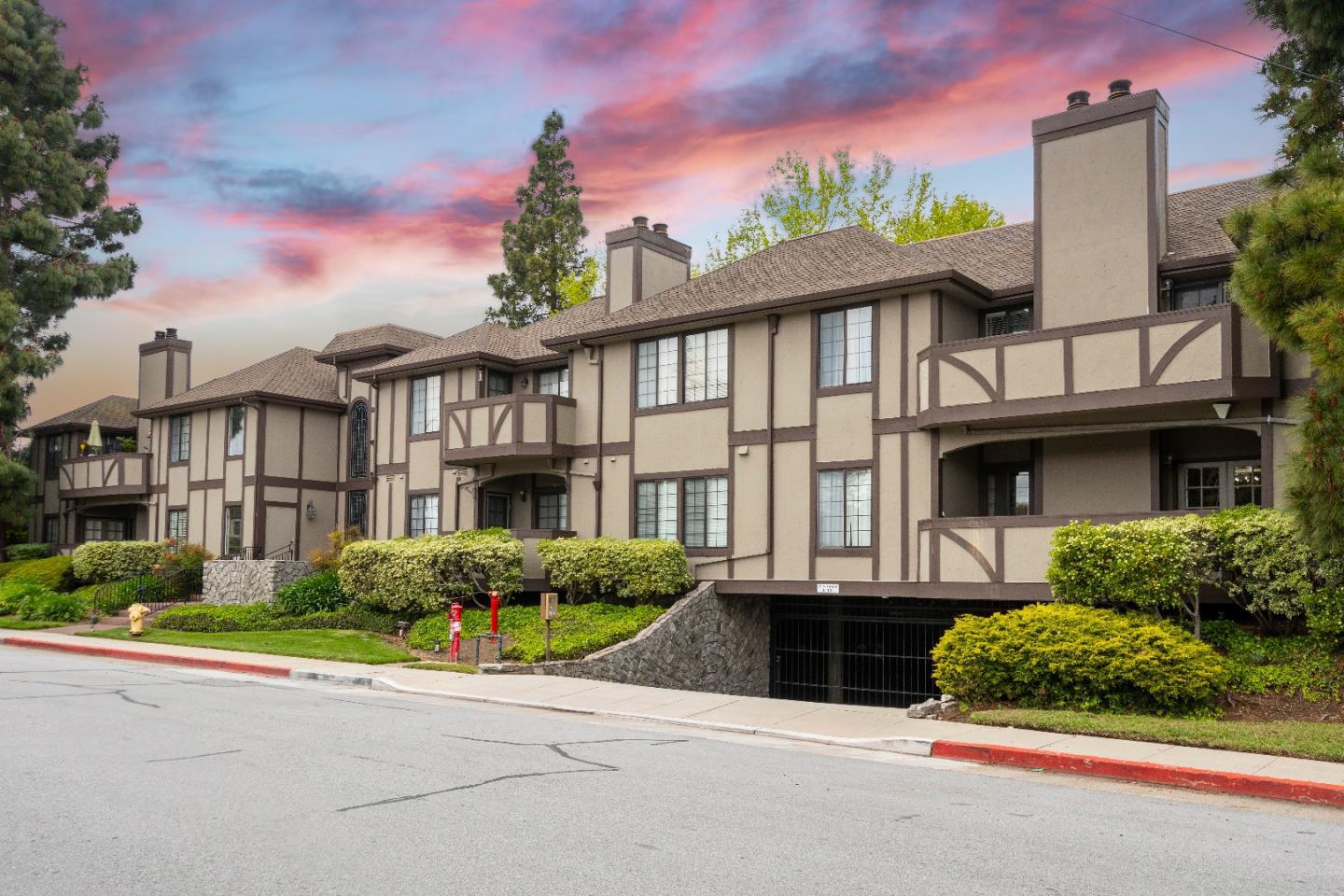 a front view of a house with a garden and trees