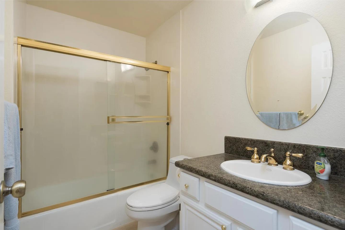 112 Madison Avenue, Unit 108 San Mateo, CA 94402 - Photo 12 of 17 a bathroom with a granite countertop sink toilet and a mirror