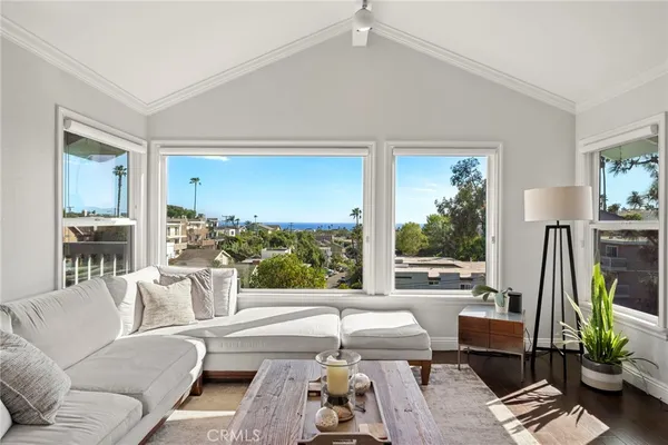 a living room with furniture a flat screen tv and a floor to ceiling window