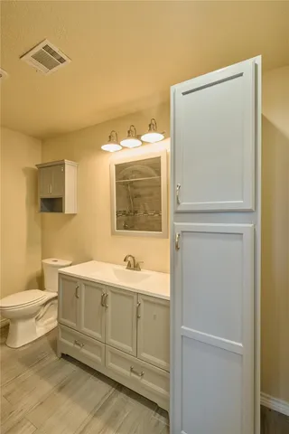 a bathroom with a toilet sink and mirror
