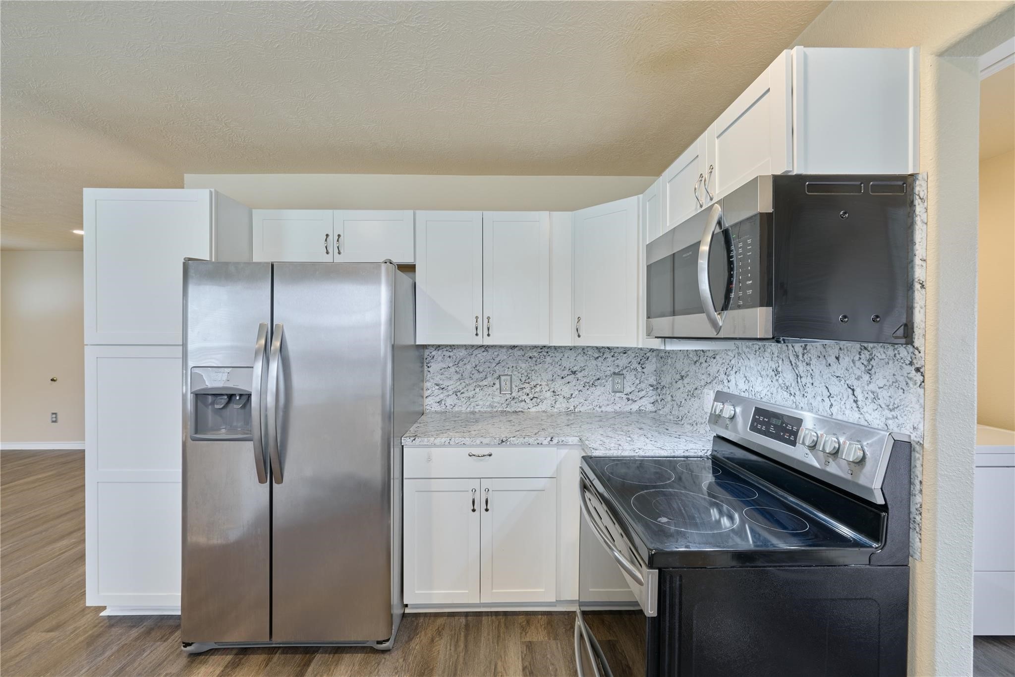 450 Ritchey Road Coldspring, TX 77331 - Photo 10 of 27 a kitchen with stainless steel appliances granite countertop a stove a refrigerator and a microwave