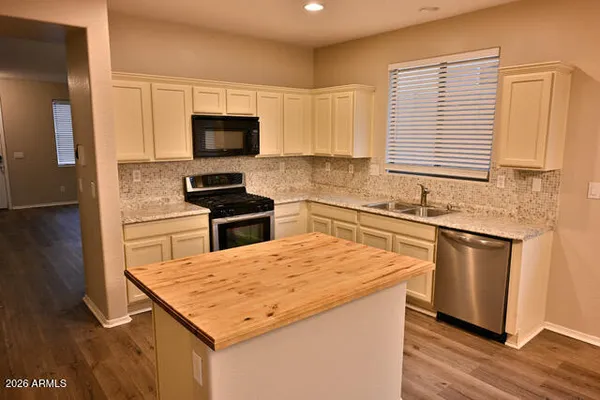 a kitchen with granite countertop a sink stove and refrigerator