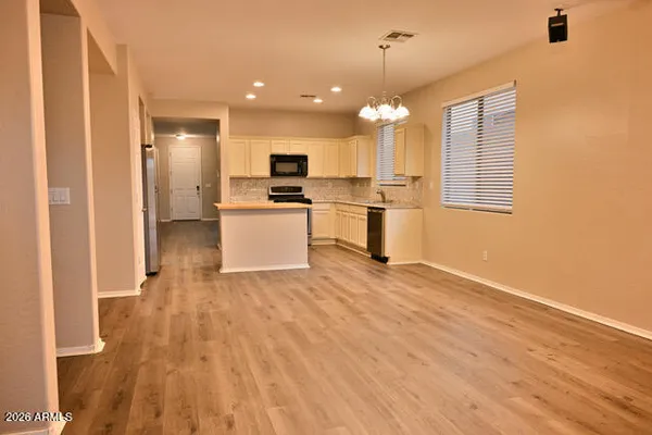 a view of a kitchen with a sink and dishwasher a refrigerator with wooden floor