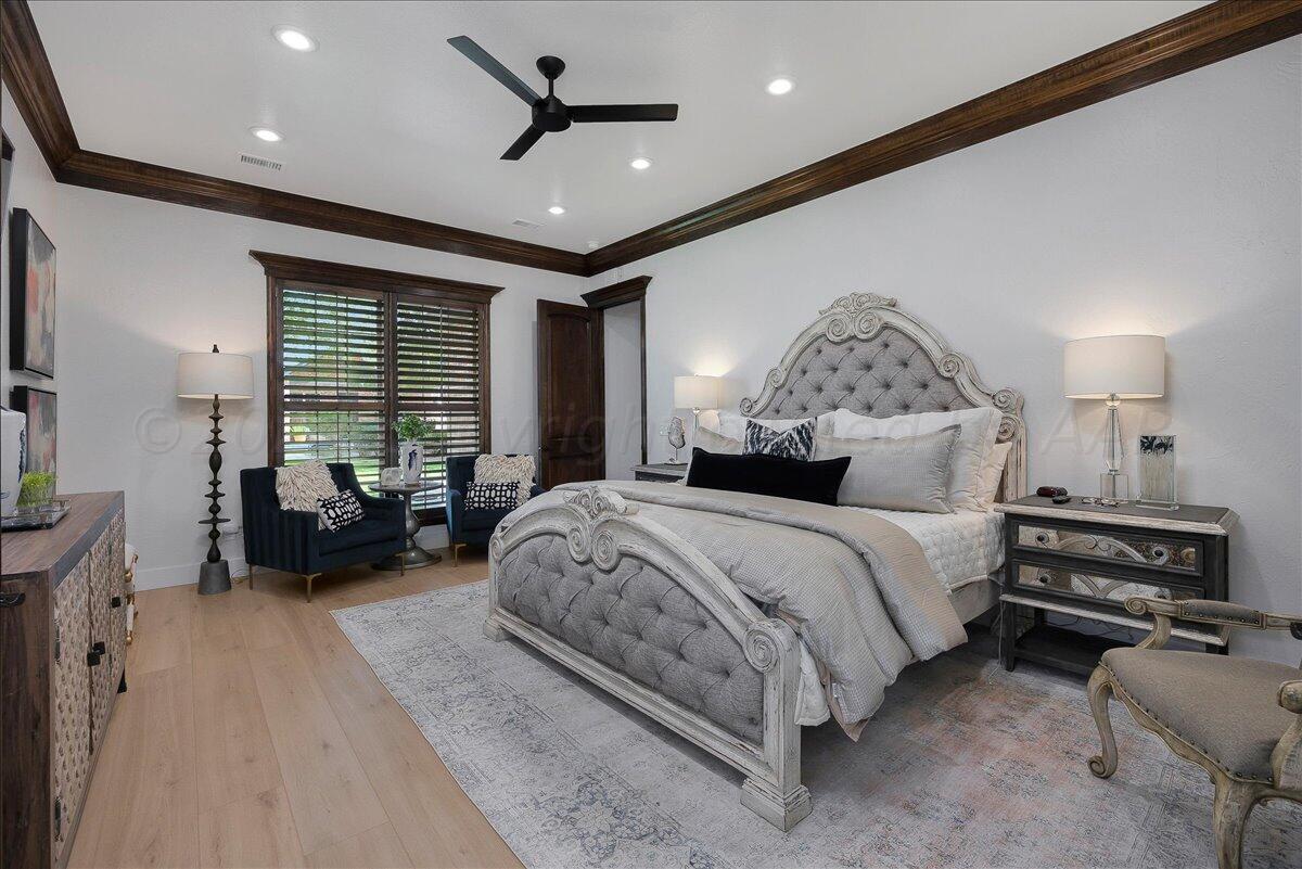 17701 White Wing Road Canyon, TX 79015 - Photo 22 of 76 a spacious bedroom with a bed a couch and a chandelier