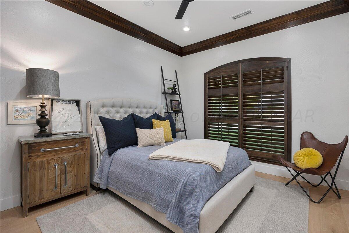 17701 White Wing Road Canyon, TX 79015 - Photo 29 of 76 a bedroom with a bed and a chandelier