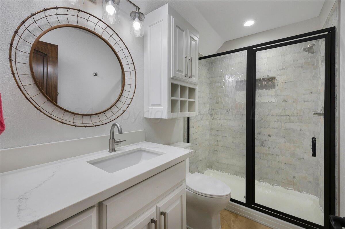 17701 White Wing Road Canyon, TX 79015 - Photo 34 of 76 a bathroom with a sink a toilet and a mirror