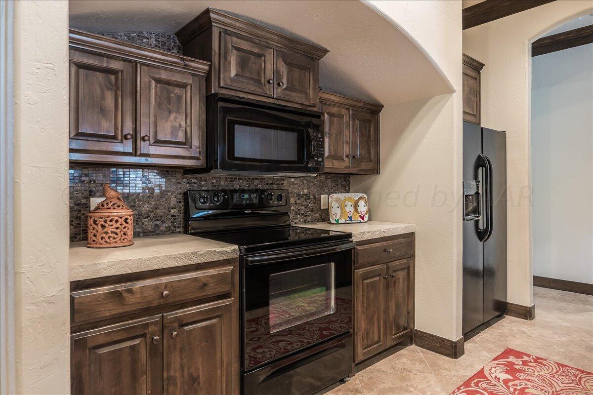 17701 White Wing Road Canyon, TX 79015 - Photo 43 of 76 a kitchen with stainless steel appliances granite countertop a stove microwave and refrigerator