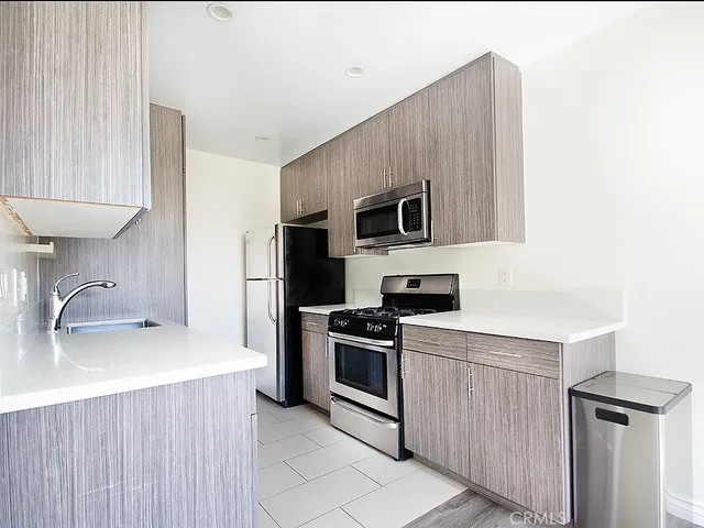a kitchen with a sink a stove top oven and stainless steel appliances