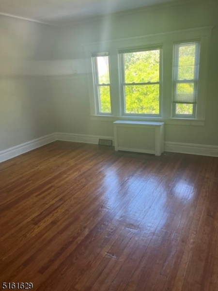 209 Hillside Avenue, Unit 2 Glen Ridge, NJ 07028 - Photo 14 of 17 a view of an empty room with wooden floor and a window
