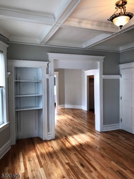 209 Hillside Avenue, Unit 2 Glen Ridge, NJ 07028 - Photo 2 of 17 a view of an empty room with closet empty shelves and wooden floor