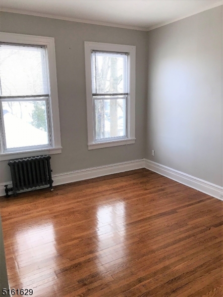 209 Hillside Avenue, Unit 2 Glen Ridge, NJ 07028 - Photo 3 of 17 an empty room with wooden floor and windows