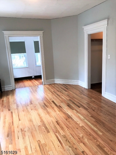209 Hillside Avenue, Unit 2 Glen Ridge, NJ 07028 - Photo 5 of 17 a view of an empty room with wooden floor and a window