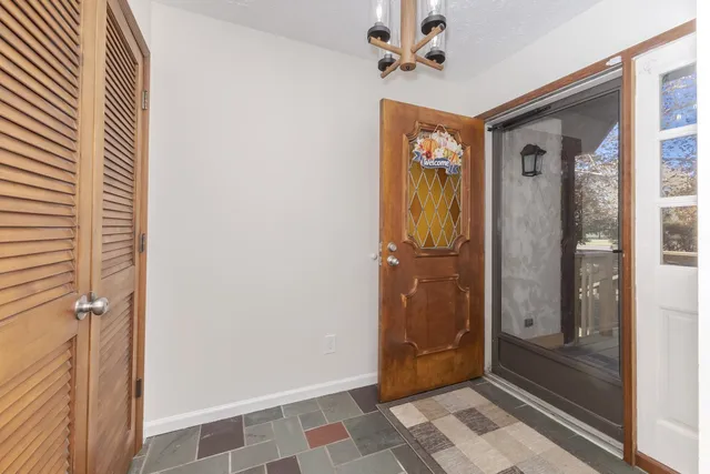 a view of a hallway with a door and a chandelier