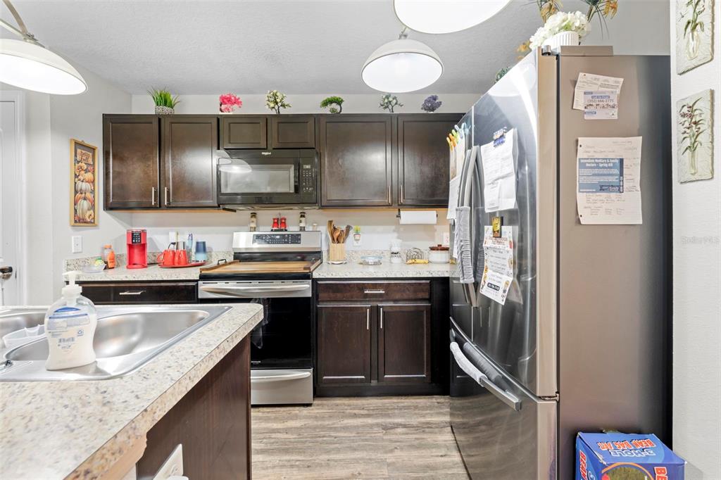 26448 Bertram Road Brooksville, FL 34602 - Photo 11 of 31 a kitchen with granite countertop a sink stove and cabinets
