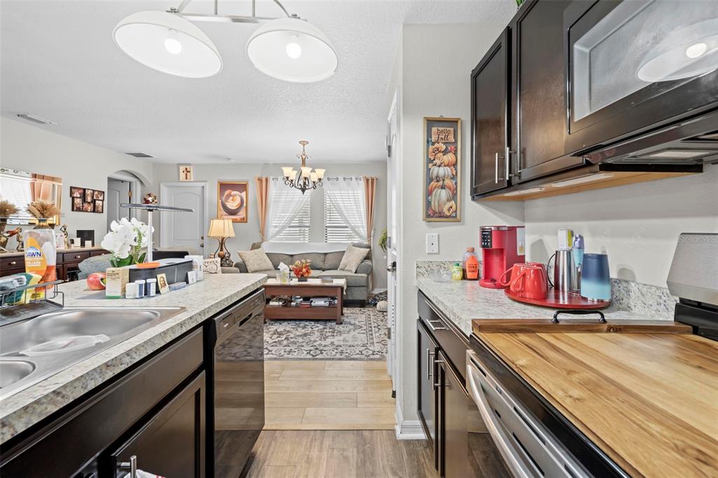 26448 Bertram Road Brooksville, FL 34602 - Photo 16 of 31 a kitchen with stainless steel appliances granite countertop a sink stove and cabinets