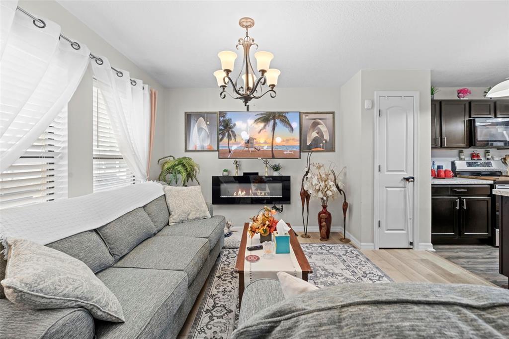 26448 Bertram Road Brooksville, FL 34602 - Photo 20 of 31 a living room with furniture a chandelier and a flat screen tv