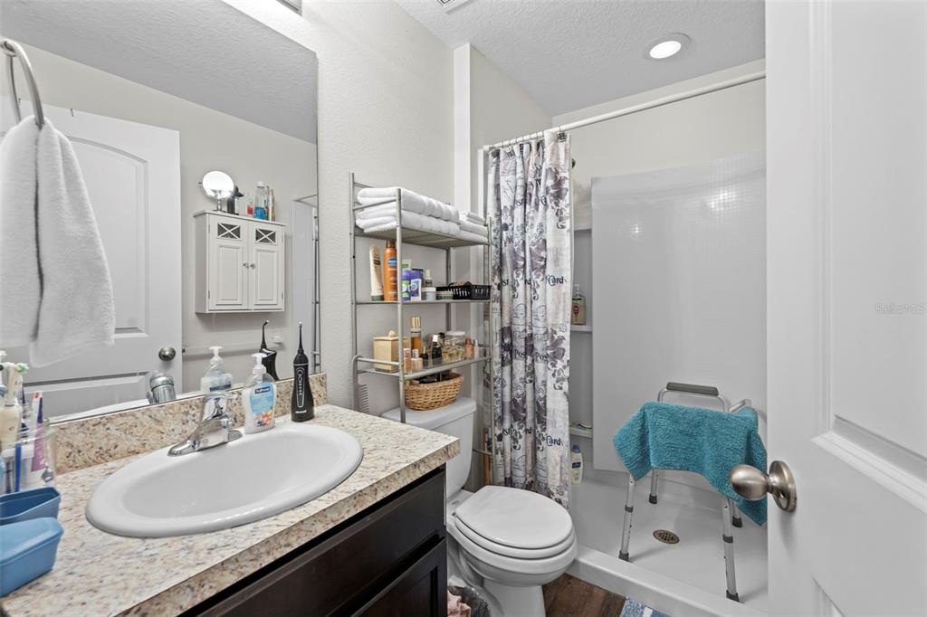 26448 Bertram Road Brooksville, FL 34602 - Photo 25 of 31 a bathroom with a granite countertop sink toilet and shower