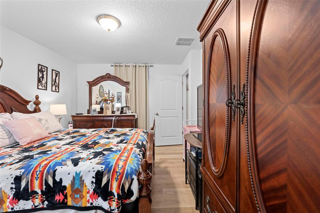 26448 Bertram Road Brooksville, FL 34602 - Photo 26 of 31 a bedroom with a bed and a painting on the wall