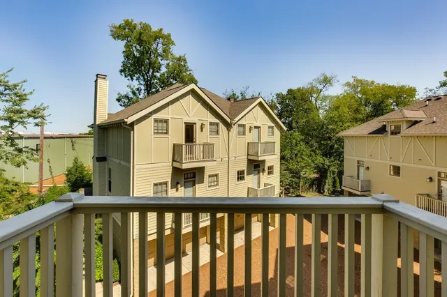 a view of a house with large windows and flower plants