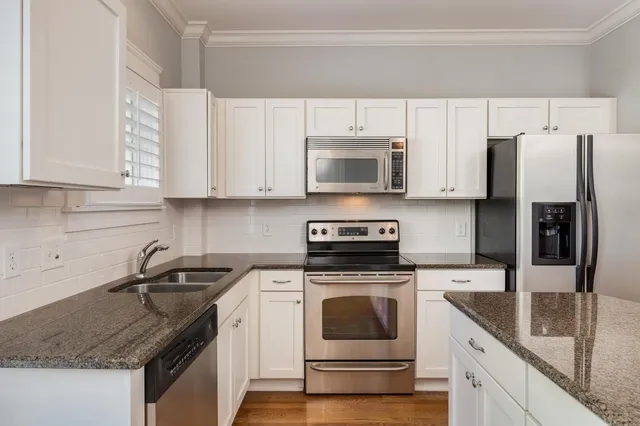 a kitchen with cabinets stainless steel appliances a sink and a counter space