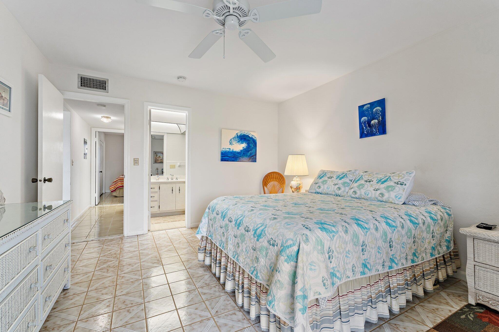 755 Saturn Street, Unit D 201 Jupiter, FL 33477 - Photo 13 of 42 a bedroom with a bed and a chandelier