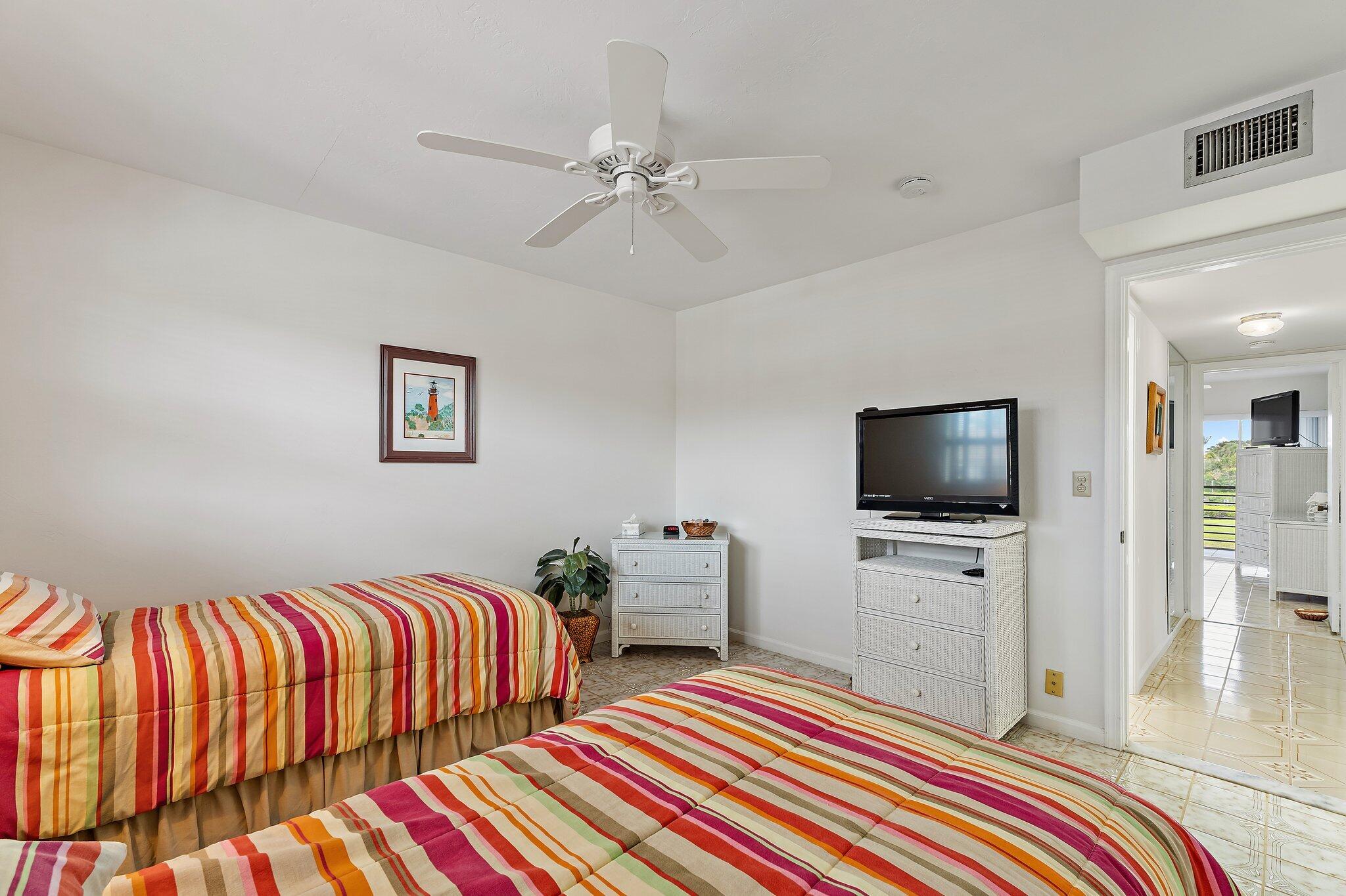 755 Saturn Street, Unit D 201 Jupiter, FL 33477 - Photo 17 of 42 a bedroom with two beds and a flat screen tv