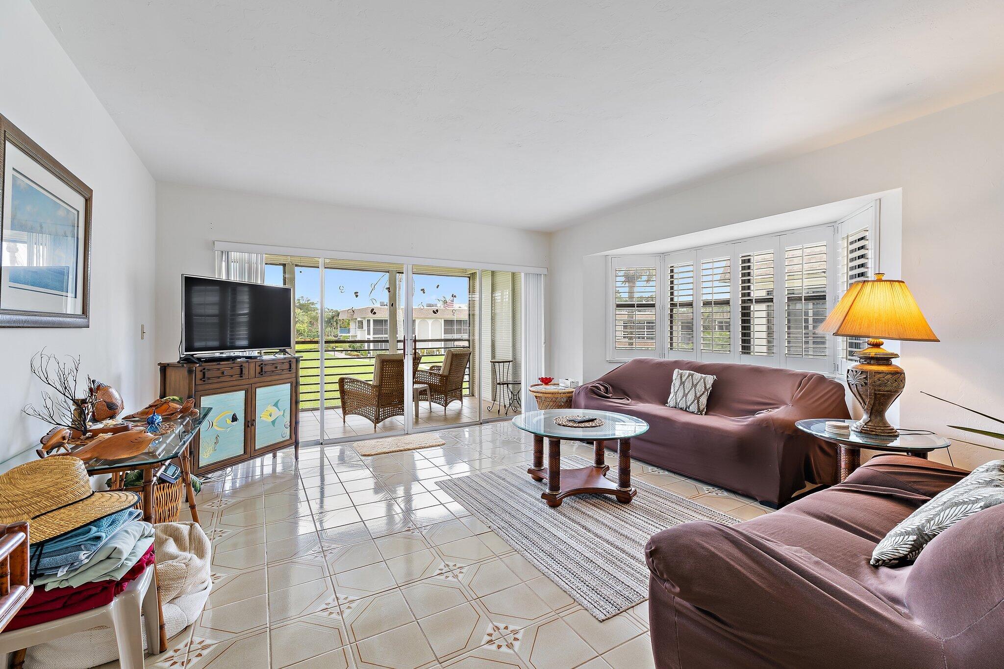 755 Saturn Street, Unit D 201 Jupiter, FL 33477 - Photo 23 of 42 a living room with furniture and a flat screen tv