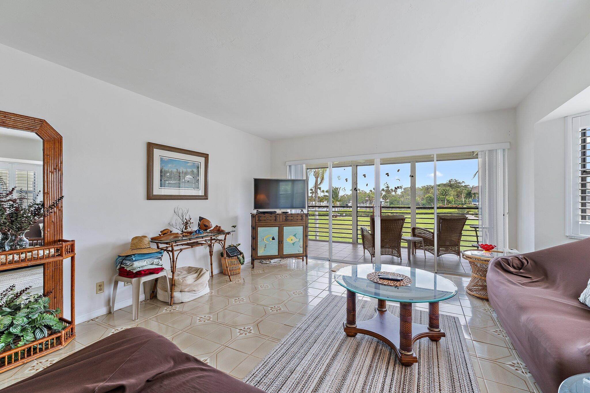 755 Saturn Street, Unit D 201 Jupiter, FL 33477 - Photo 24 of 42 a living room with furniture and a floor to ceiling window