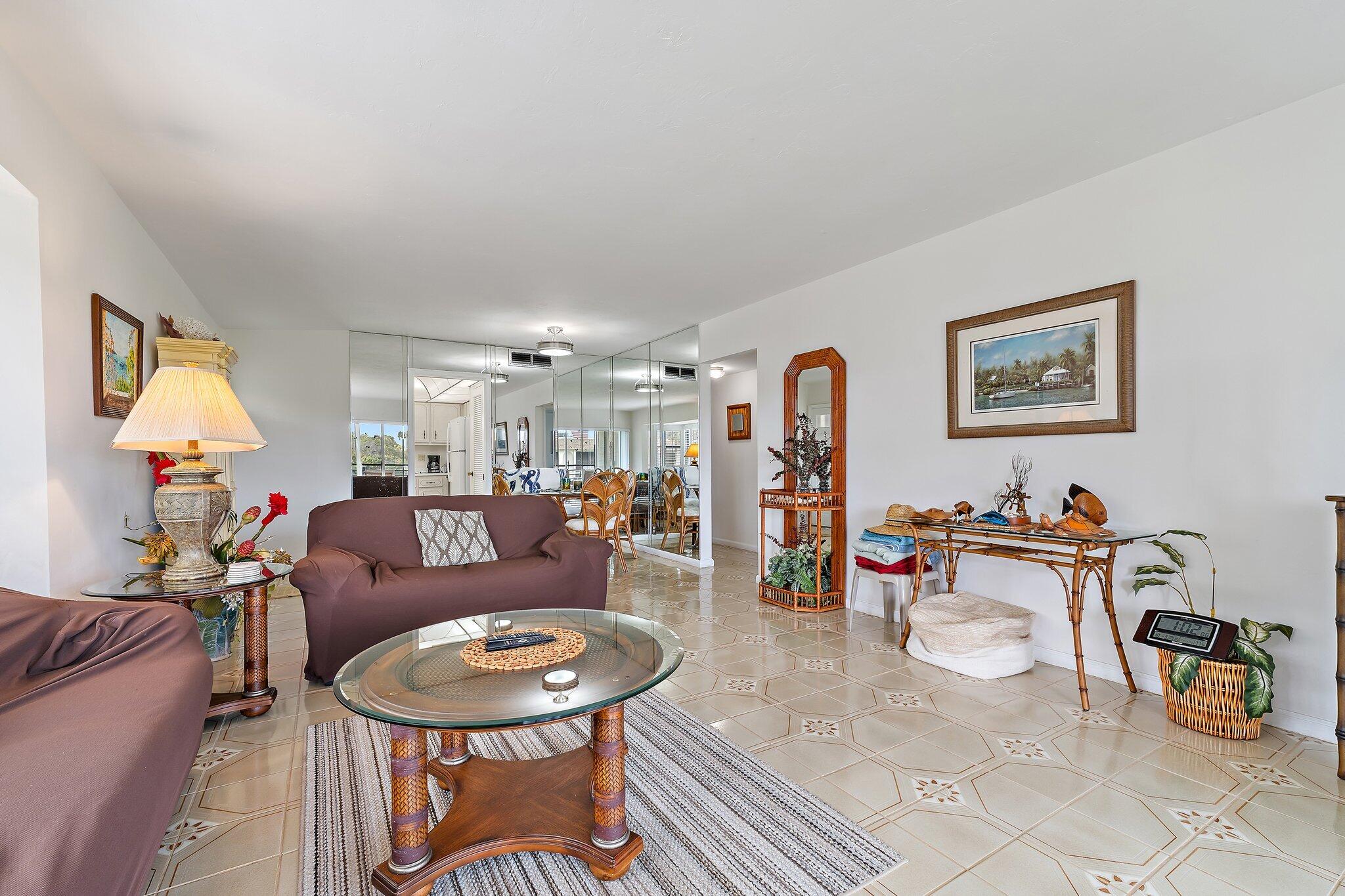 755 Saturn Street, Unit D 201 Jupiter, FL 33477 - Photo 26 of 42 a living room with furniture and a dining table with rug