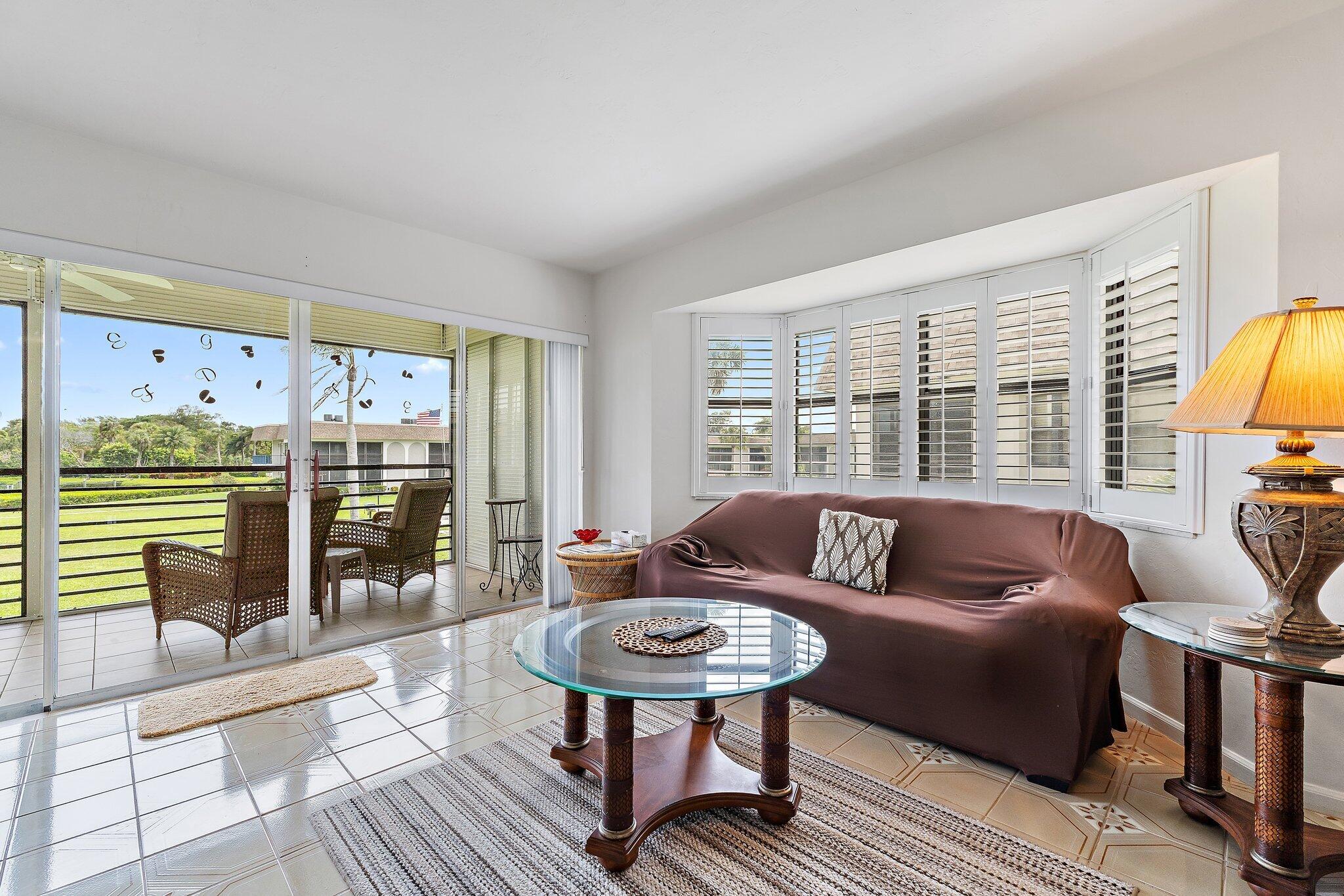 755 Saturn Street, Unit D 201 Jupiter, FL 33477 - Photo 27 of 42 a living room with furniture and a floor to ceiling window