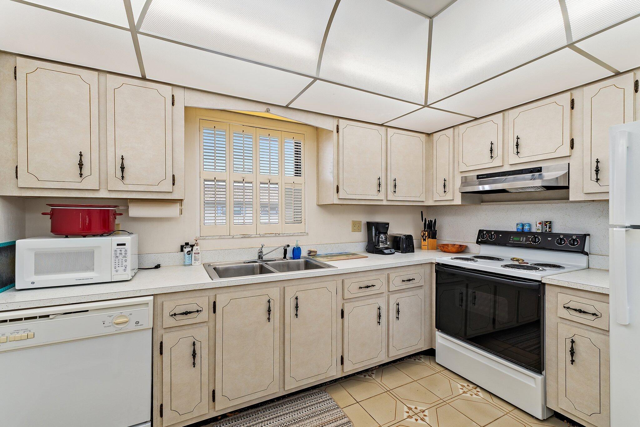 755 Saturn Street, Unit D 201 Jupiter, FL 33477 - Photo 30 of 42 a kitchen with stainless steel appliances granite countertop a sink a stove and cabinets
