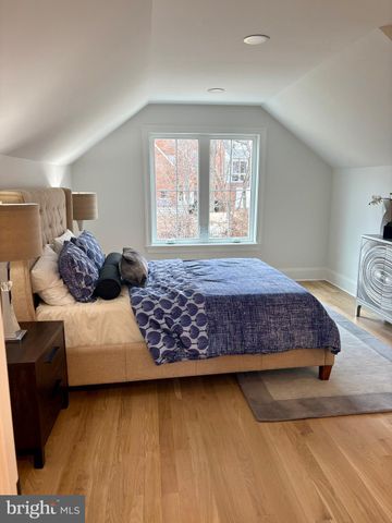 a bedroom with a bed and a lamp on dresser