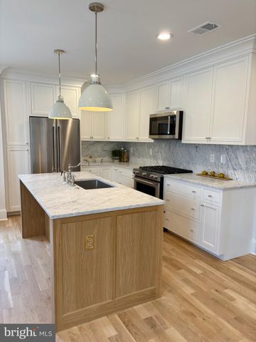 a kitchen with a stove a sink a refrigerator and a microwave