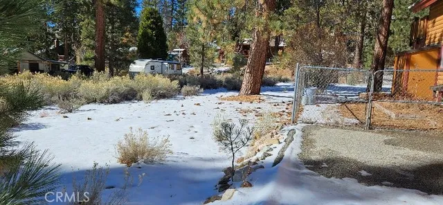 a view of a yard with wooden fence