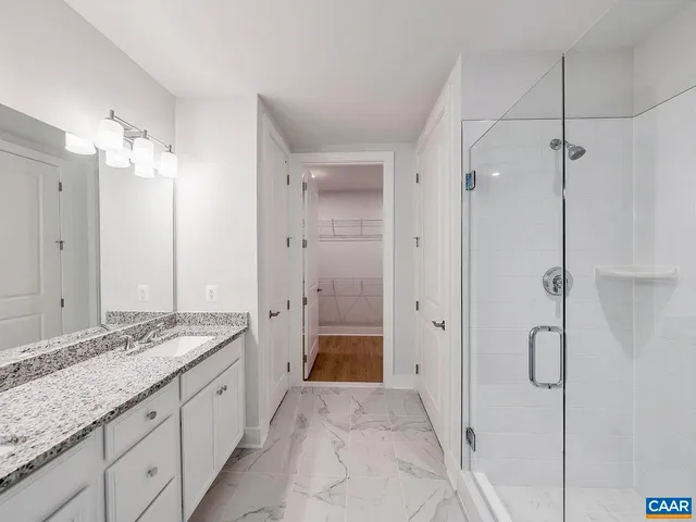 a spacious bathroom with a granite countertop sink mirror and shower