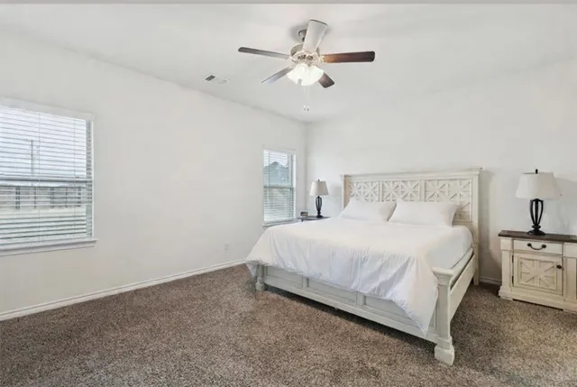 a bedroom with a bed chandelier and a window