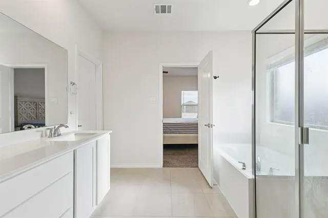 a en suite bathroom with a sink a mirror and a shower
