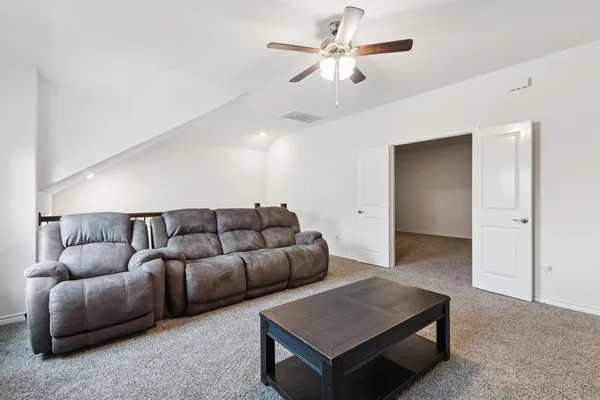 a living room with furniture and a ceiling fan