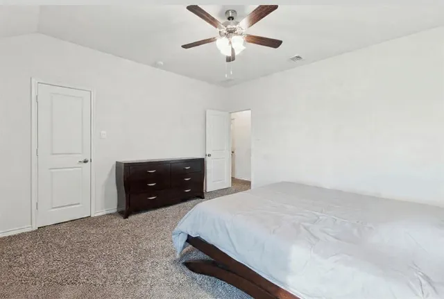 a bedroom with a bed and a ceiling fan