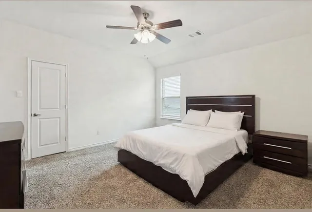 a large bed sitting in a bedroom and chandelier