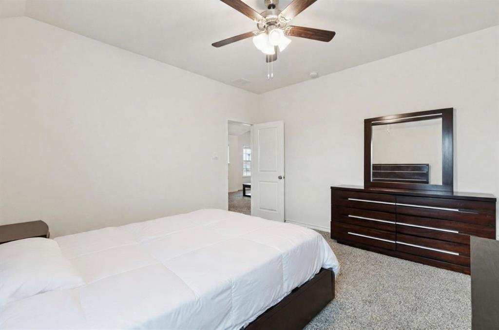 3400 Honey Hl Road Aubrey, TX 76227 - Photo 29 of 39 a bedroom with a bed and a chandelier