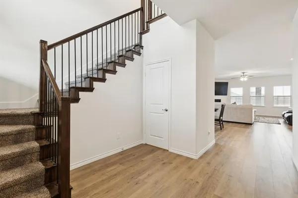 a view of a hallway with wooden floor and staircase