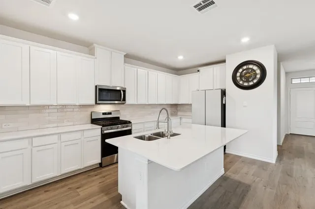a kitchen with a sink a stove top oven and white kitchen
