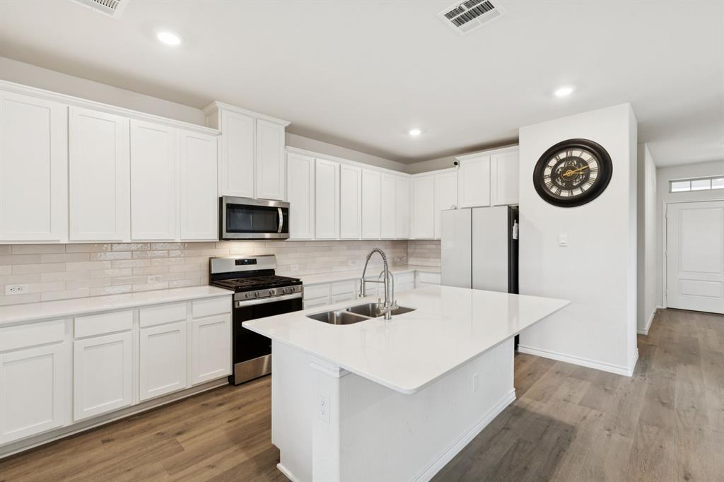3400 Honey Hl Road Aubrey, TX 76227 - Photo 6 of 39 a kitchen with a sink a stove top oven and white kitchen
