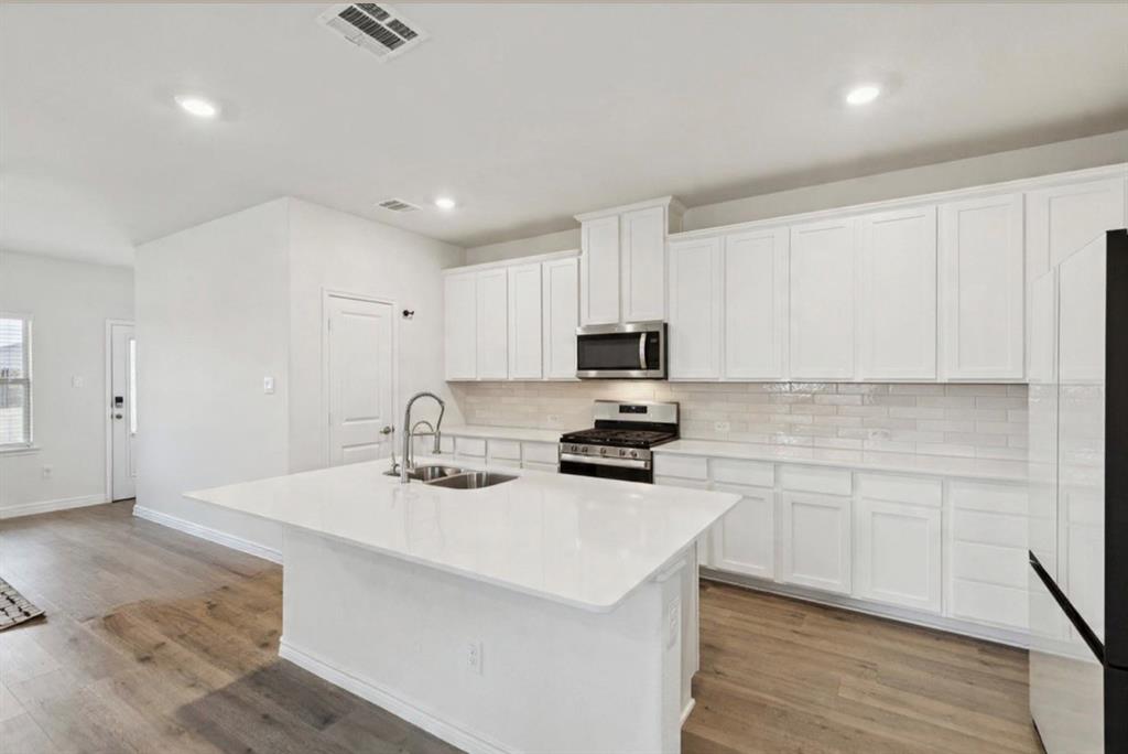 3400 Honey Hl Road Aubrey, TX 76227 - Photo 7 of 39 a kitchen with sink a microwave and cabinets